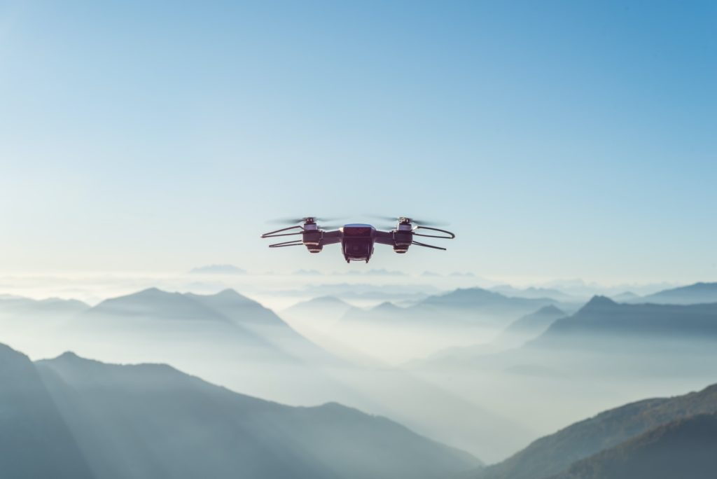 Drone volant dans le ciel au-dessus des collines brumeuses